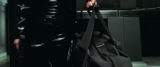 Close on a black coat and duffel bag as the camera begins to pull back.