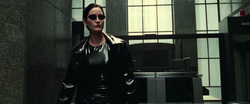 Trinity revealed in a black vinyl coat and sunglasses.