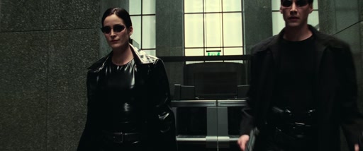 Trinity and Neo walking forward together through the lobby.