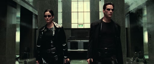 Wide view of Neo and Trinity striding through the lobby.